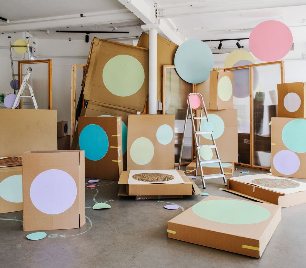 Sculptural installation built from cardboard boxes, painted with circles.