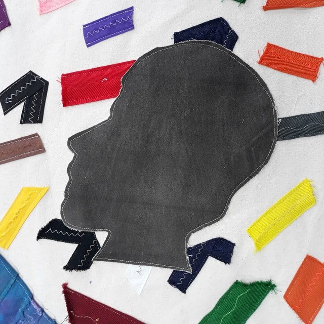 Silhouette of a person's head on a white background, surrounded by brightly coloured rectangles.