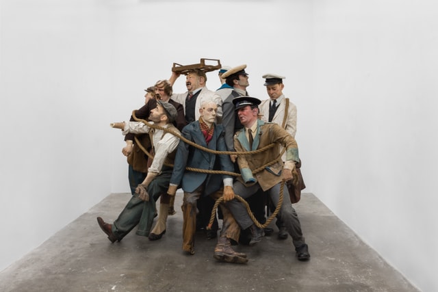 Sculpture of a group of men in various worker's uniforms.