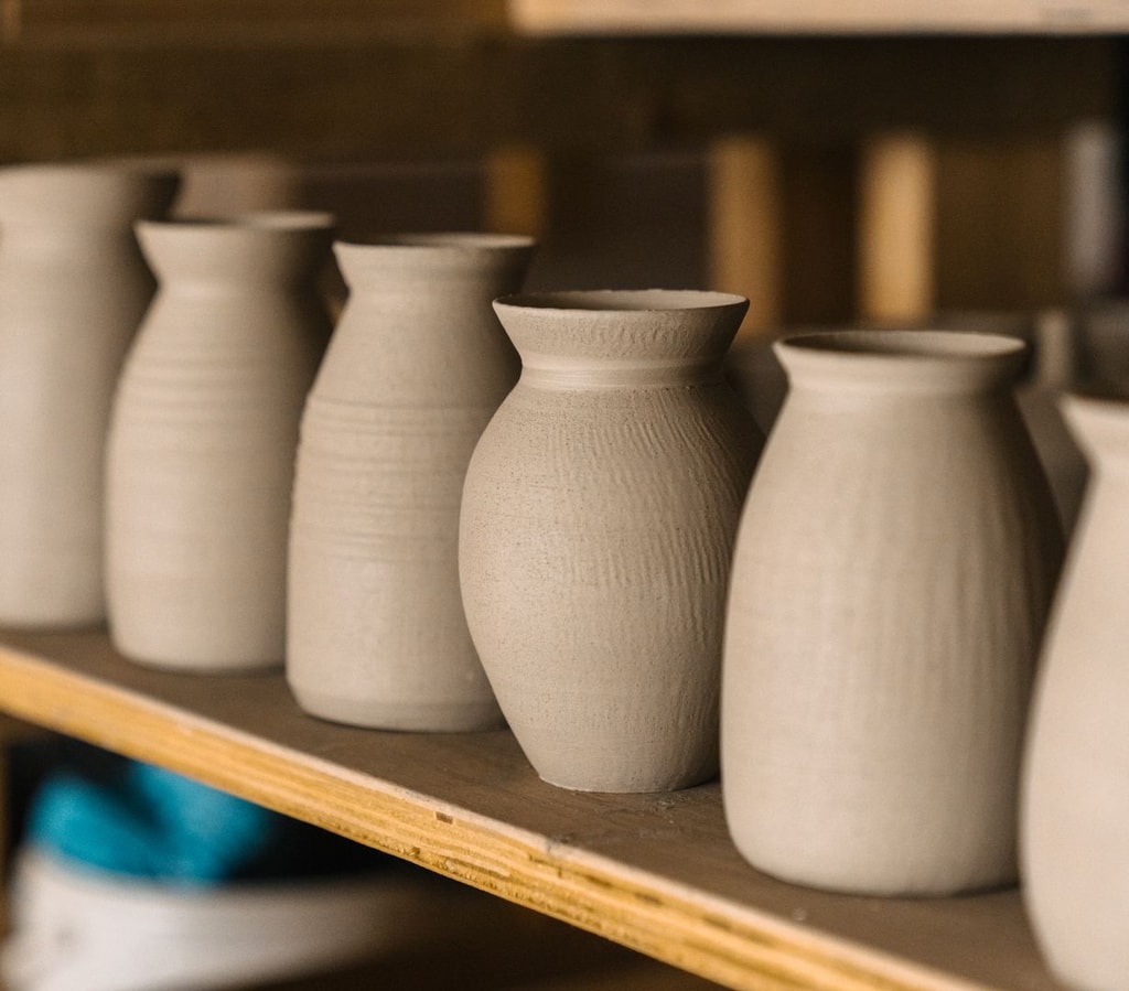 Row of unfired clay vases.