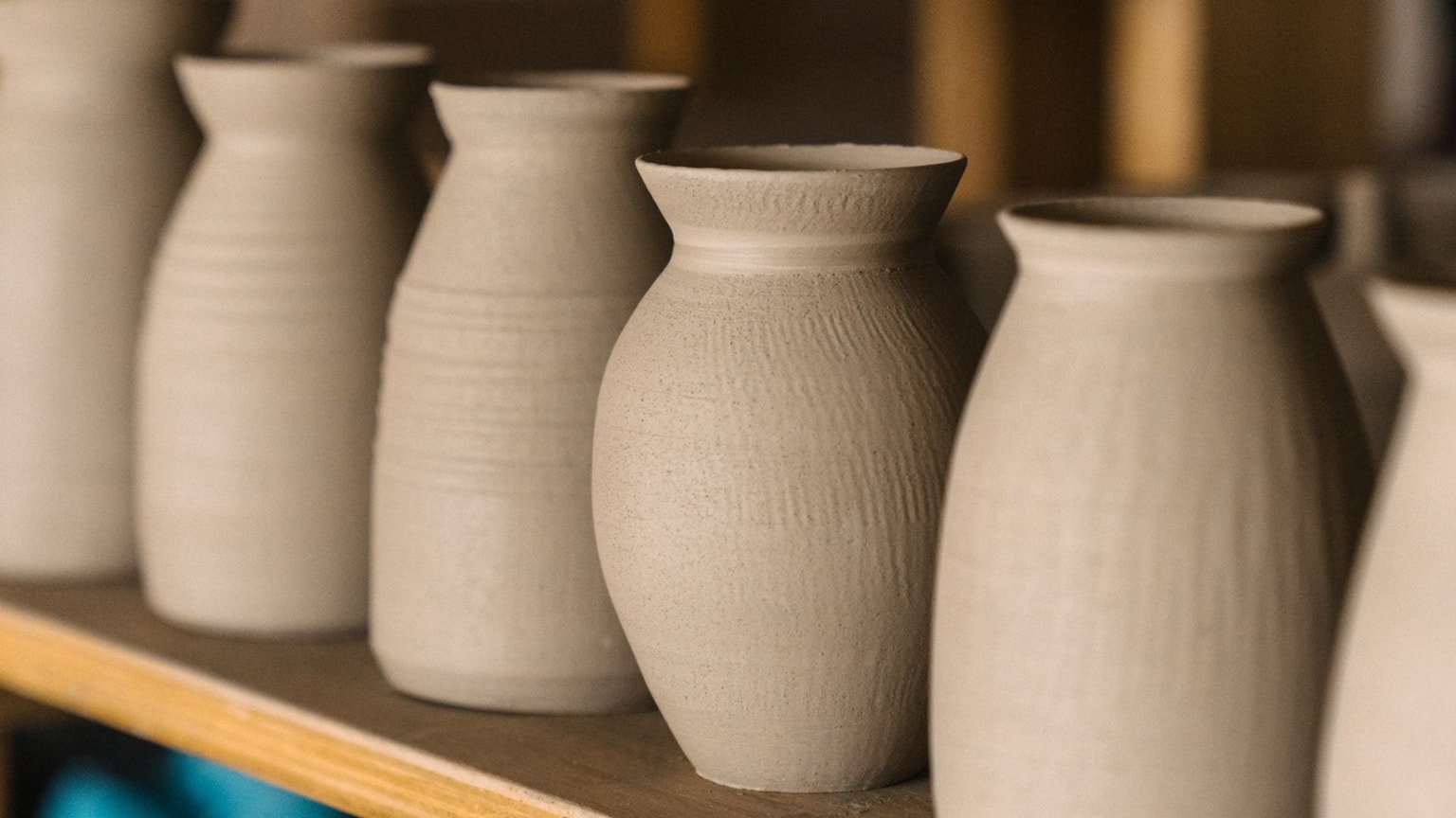 Row of unfired clay vases.