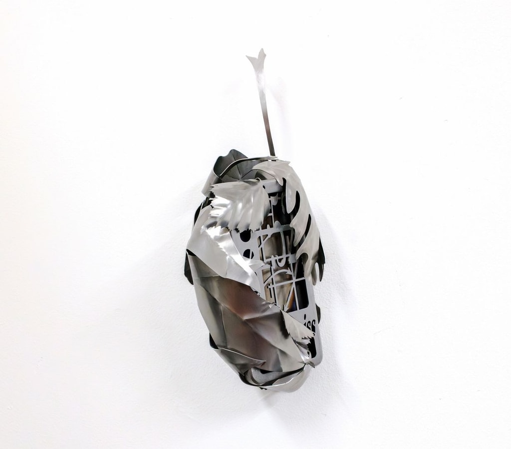 A small box-like object encased in a metal leaf.