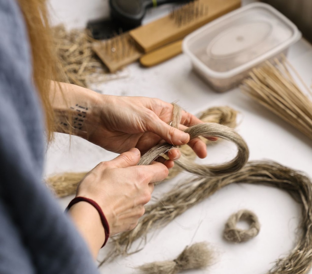 A woman's hands braiding some flax.