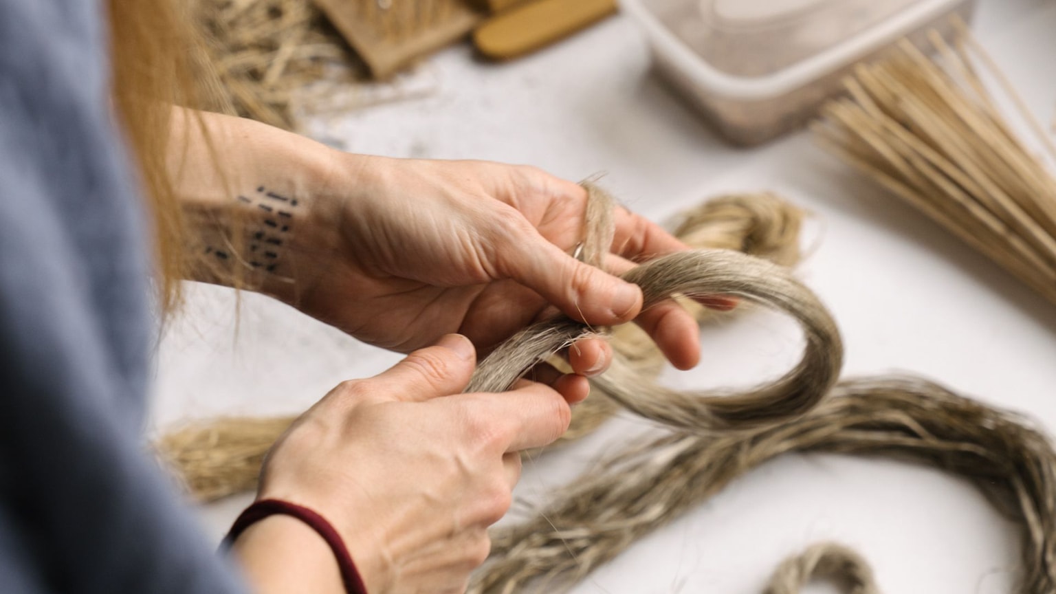 A woman's hands braiding some flax.