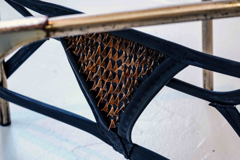 A piece of material strapped to a metal frame, with thorns piercing through.